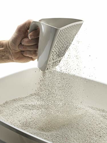 Hand using a scoop to sift cat litter.