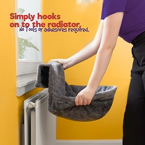 Person attaching a cat bed to a radiator.